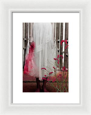 Woman in a Vintage White Lace Dress, cropped at waist, Standing With a Bloody Hand Dripping Down Her Dress in front of a Gate-Framed Print
